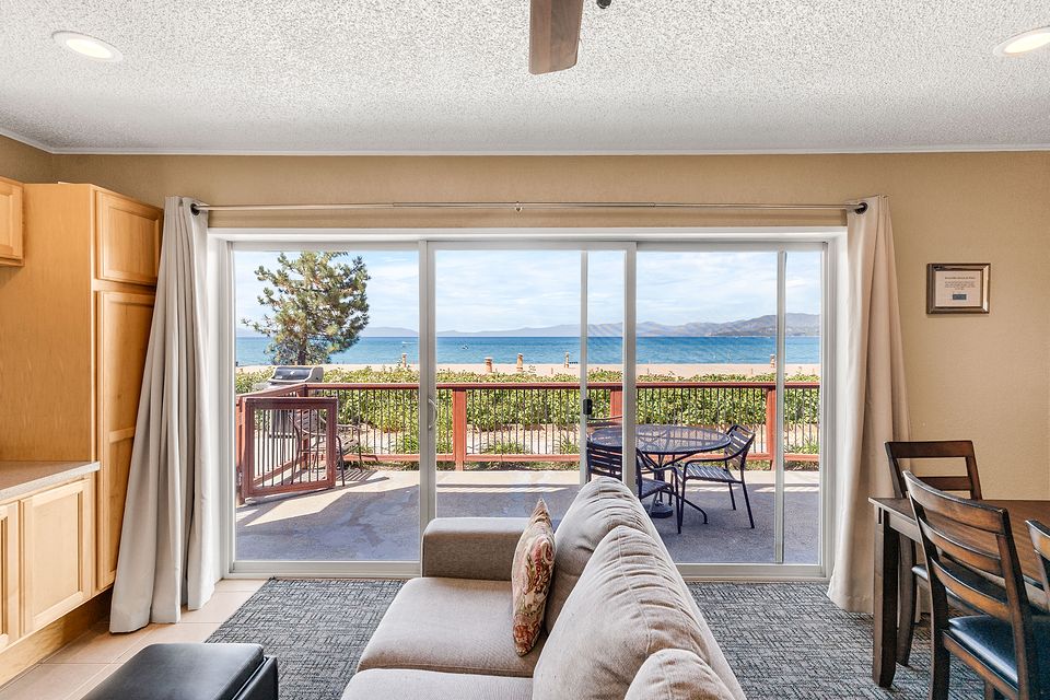 Living room and the slider to the lake-view deck, Unit L at the Beachcomber Inn