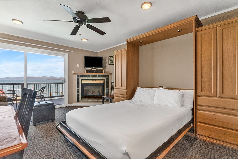 The wall bed down, with the fireplace and the lake through the slider, Unit P at the Beachcomber Inn