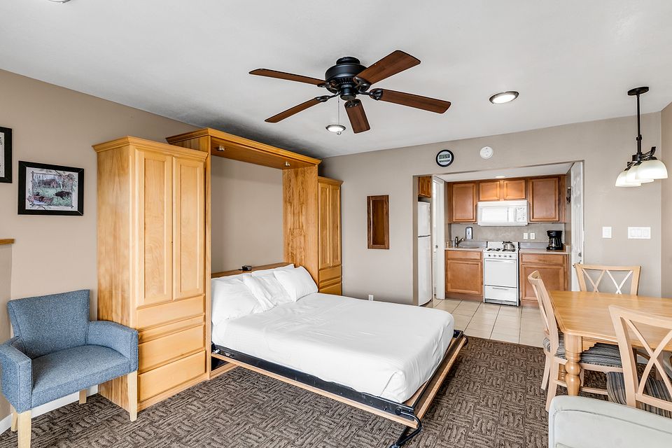 The wall bed, dining table, and kitchen, Unit S at the Beachcomber Inn